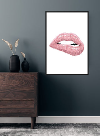 Poster of glossy pink lips on white background, displayed above a wooden dresser in a modern room.