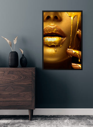 Golden lips fashion poster featuring glossy gold lips and honey dripping on a face, displayed in a modern room setting.