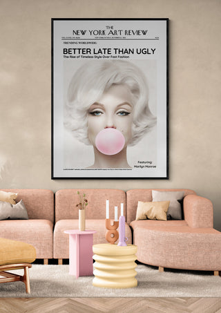Art poster of Marilyn Monroe blowing bubblegum, styled as a vintage art review magazine cover above a modern sofa.