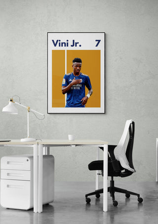 Vini Jr. Real Madrid football poster on a wall above a modern office desk and chair setup.