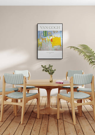 Framed Van Gogh "The Bedroom" poster hanging above a round dining table with four chairs in a modern room.