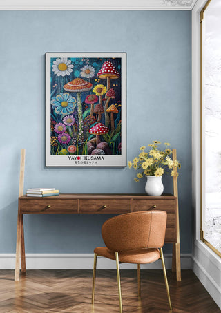Framed Yayoi Kusama "The Daisy" artwork featuring colorful flowers and mushrooms, displayed above a desk in a modern room.