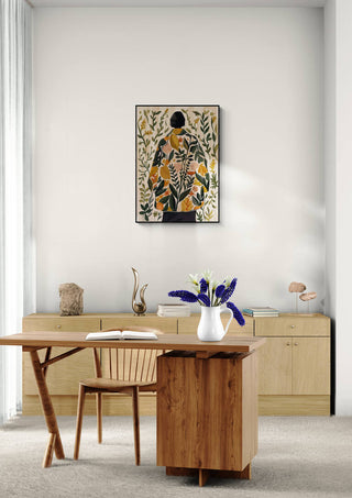 Framed Whispers of Spring by Elara Monet displayed above a minimalist desk with flowers and natural decor.