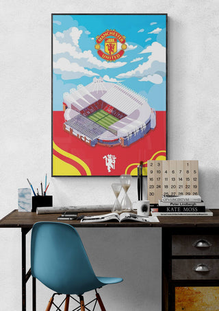 Poster of Old Trafford stadium with Manchester United logo, displayed above a desk in a modern workspace.